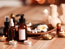 Bottles of essential oil and candles on table in spa salon